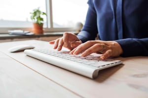 woman-using-computer-on-wooden-table-2023-11-27-05-05-19-utc